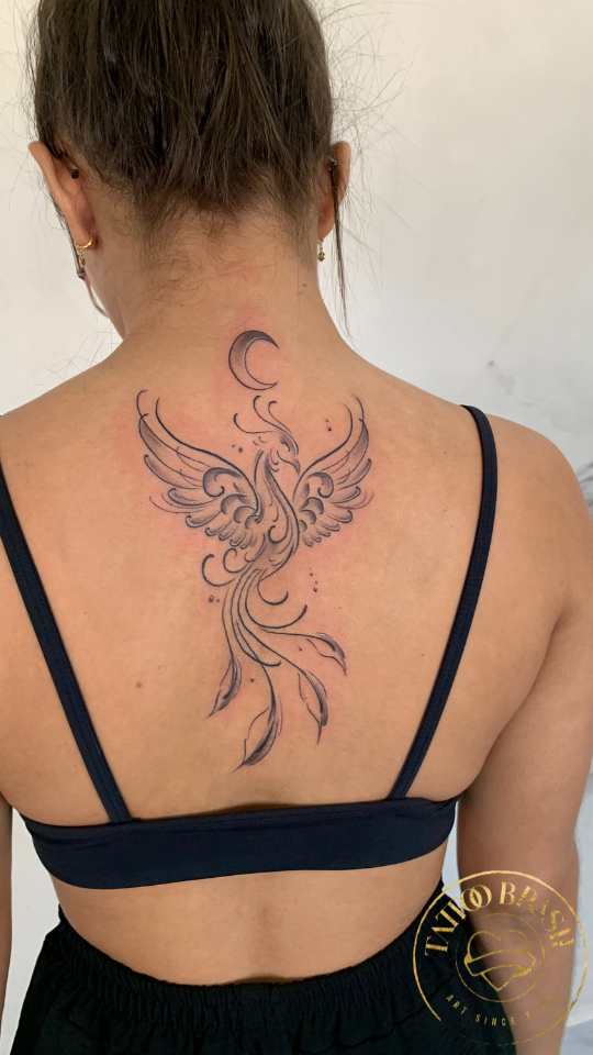 Tatuagem delicada de fênix nas costas feminino em Natal