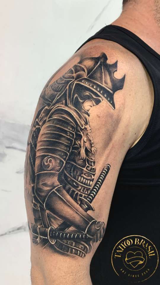 Tatuagem realista de um guerreiro samurai com armadura no ombro.